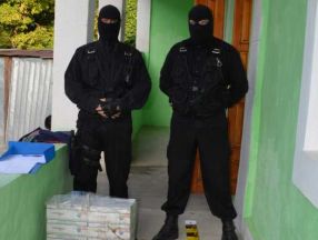 Niște polițiști de frontieră cu cagule, mîndri că tocmai au capturat 10 cartoane de țigări